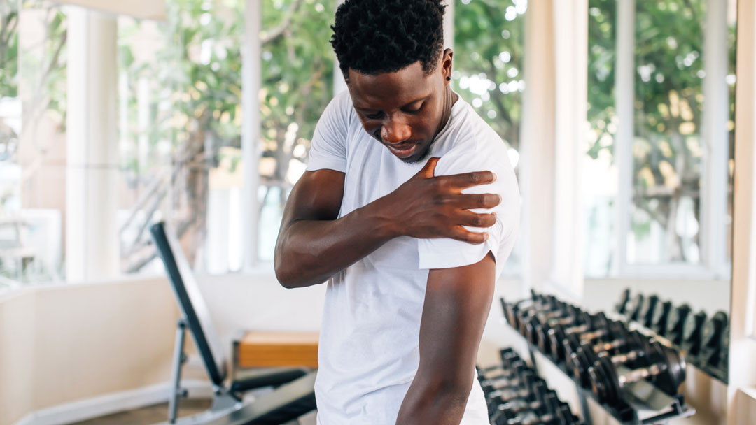 Person pausing during activity due to muscle pain that could signal an injury